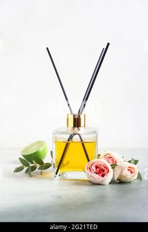 Reed diffuser with roses and lime on light background Stock Photo