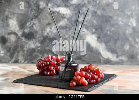 Reed diffuser with grapes on grunge background Stock Photo