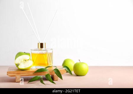 Reed diffuser with apples on table Stock Photo