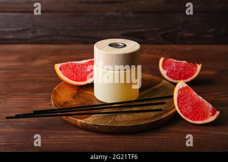 Reed diffuser with grapefruit on wooden table Stock Photo