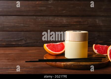 Reed diffuser with grapefruit on wooden table Stock Photo