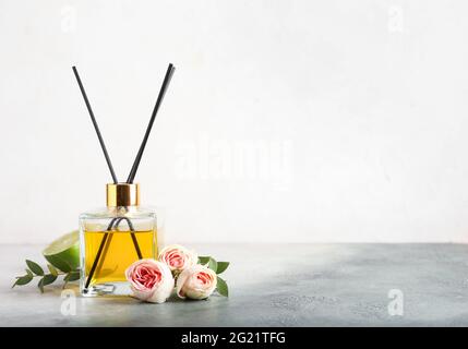 Reed diffuser with roses and lime on light background Stock Photo