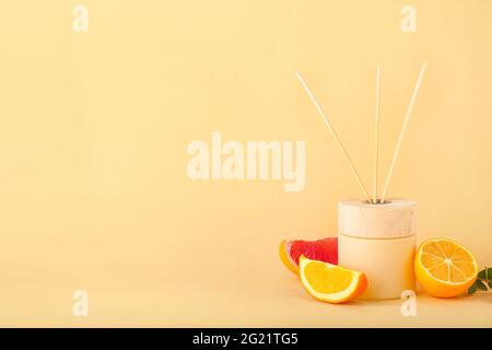 Reed diffuser with citrus fruits on color background Stock Photo