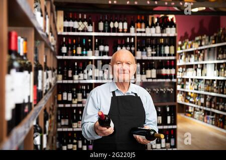 vintner offering wine in modern wineshop Stock Photo