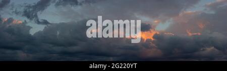 Dark sky with orange clouds illuminated by the sun at sunset. Dramatic landscape of the evening sunset Stock Photo