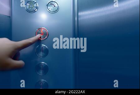 Person pressing on the fifth floor of elevator button. Hand press number 5 on button inside office or hotel lift. Index finger press on lift button. Stock Photo