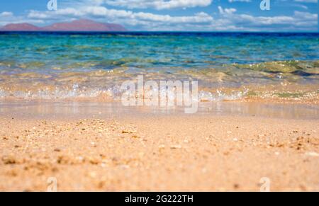 Soft blue ocean wave or clear sea on clean sandy beach summer concept. Beautiful Beach Ocean Scene with Blue Wave on Seashore with Reflection of Sun R Stock Photo