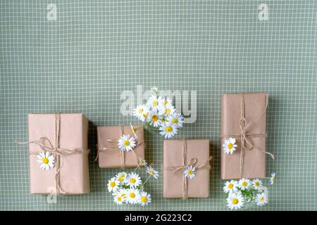 Set of gifts box wrapped with brown craft paper and decorated with natural chamomile flowers. Top view, flat lay, place for text. High quality photo Stock Photo