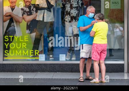 Summer fashion style outsde Marks & Spencers, M&S shoppers preparing to enter store in Southport, UK Stock Photo