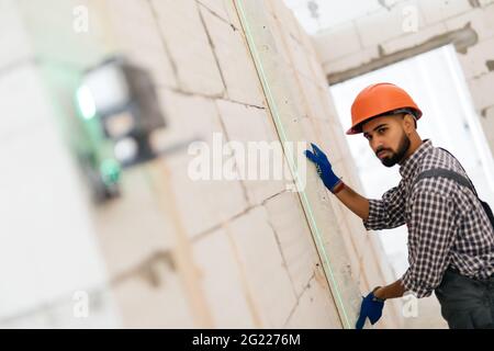 Laser level measuring tool and tape measure hand hold drill for accuracy on wood wall Stock Photo