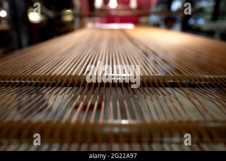 Golden thread on a vintage loom at the historical Bevilacqua weaving in Venice since 1875. Stock Photo