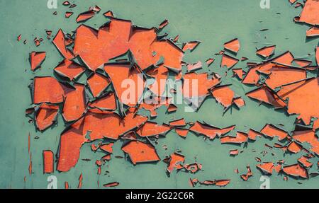 Orange painted wall with green color peeling off Stock Photo