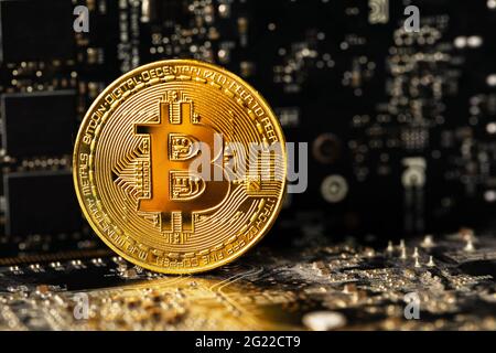 Dark gold bitcoin on crypto mining GPU circuit board computer hardware Stock Photo