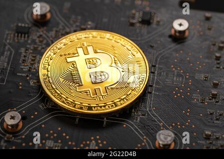 Gold bitcoin on crypto mining GPU circuit board computer hardware Stock Photo