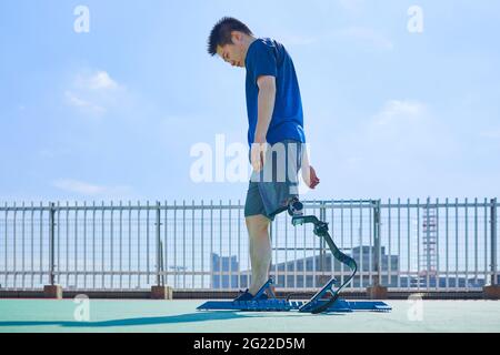 Japanese amputee athlete training on rooftop Stock Photo
