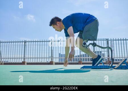 Japanese amputee athlete training on rooftop Stock Photo
