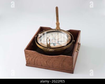 Azimuth Compass. Azimutskas in Cardanus ring in a wooden box, the lid of which is missing. The Cardanus ring can be rotated for polls. The compass has a fixed pelorus, the boiler is weighted with a lead weight below. The rose is made of mica, plaked with paper on both sides; He is colored by hand and balanced with some black varnish below. Stock Photo
