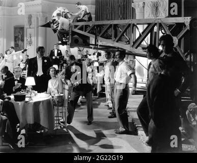 ARTHUR BYRON PAUL LUKAS as Philo Vance ROSALIND RUSSELL Director EDWARD L. MARIN and Cinematographer CHARLES G. CLARKE (white shirt) with Movie Crew on set candid during filming of THE CASINO MURDER CASE 1935 director EDWIN L. MARIN from the book by S.S. VAN DINE wardrobe Dolly Tree Metro Goldwyn Mayer Stock Photo