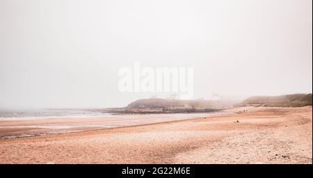 View of the beach at Seaton Sluice Northumberland, UK. Taken on a misty day as the mist & low cloud cling to the east coast of England. Stock Photo