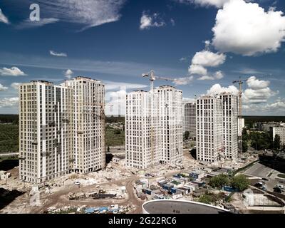 Bright aerial photo of construction site. New houses with construction cranes. City development Stock Photo