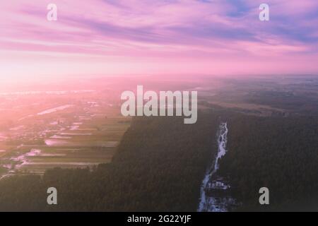 Rural landscape in winter, countryside with pine forest. Sunset over countryside. Aerial view Stock Photo