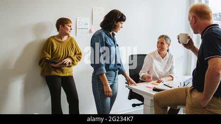 Colleagues talking and working together in office. Creative team discussing new project. Stock Photo