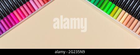 Felt-tip pens for drawing on a beige background. Long banner with place for text for stationery store, stationer's, advertisement or sale. Stock Photo