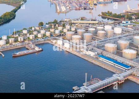 Aerial view of large fuel storage tanks at oil refinery industrial zone in the cargo seaport Stock Photo