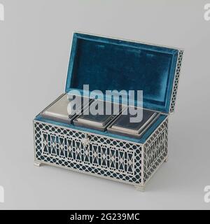 Tea box with two tea buses and a mixing bus. The rectangular wooden box is divided into three compartments on the inside by means of two wooden sliders. Both the interior and the sliders are covered with blue velor. It is caught in a silver holder that has a hinged lid, containing the loose wooden lid of the coffin. The holder rests on four hollow vaulted, fluted legs, upside down and bottomed by profile edges. It has a bottom of smooth silver but has been opened to all other sides. The four sides of the coffin holder each exhibit a field of angular guilloches against a background of railing w Stock Photo