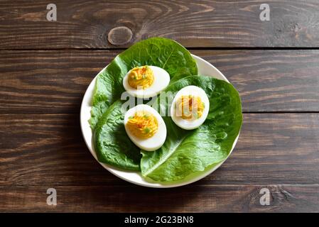 Deviled eggs with paprika, mustard and mayonnaise on plate over wooden background. Close up view Stock Photo