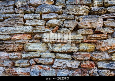 An old wall of stone. Old masonry. The stone is in the wall. stone fence. Stock Photo