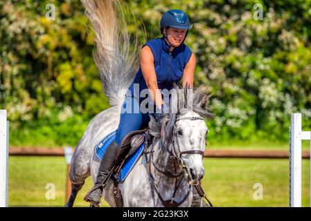 Flying tail. Rebecca Markillie riding Turbine Breeze while horse jumping training at the Speetley Equestrian Centre, Barlborough, Chesterfield, UK Stock Photo