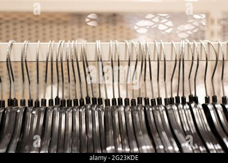cloth hanger hanging on display inside clothing shop outlet. Concept of clearance sale and shopping Stock Photo