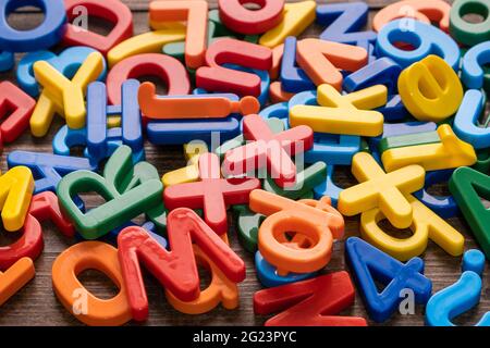 Top view of colorful plastic letters and numbers on wooden background Stock Photo