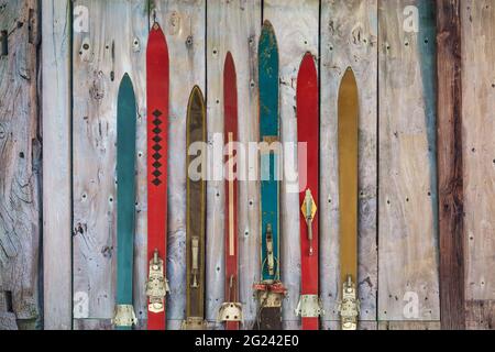 Collection of vintage wooden weathered ski's in front of an old barn Stock Photo