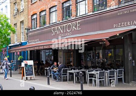 Santore Italian restaurant and pizzeria exterior people sitting at tables outside in Exmouth Market street Clerkenwell London England UK  KATHY DEWITT Stock Photo