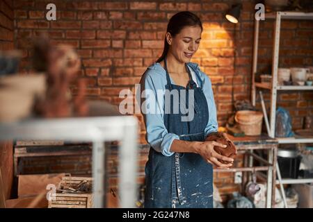 Happy cheerful caucasian craftswoman working in art studio Stock Photo