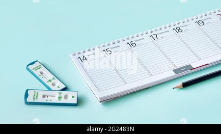 Banner with shnelltest, weekly planner, calendar, pencil on mint blue table. Schnelltest means rapid corona test in German language. Express test is Stock Photo