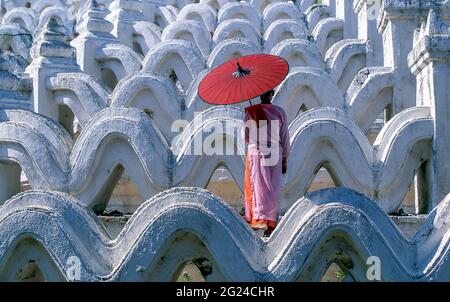 Myanmar, Mingun, Mandalay Division, Buddhist nun standing on white arches of Hsinbyume Pagoda Stock Photo