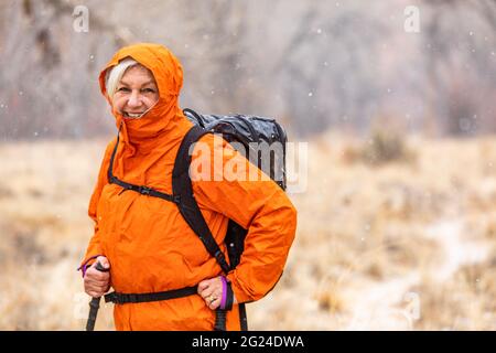 USA, Utah, Escalante, Woman hiking during snow flurry in Grand Staircase-Escalante National Monument Stock Photo