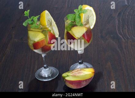 Peach in white wine with lemon and mint leaves Stock Photo