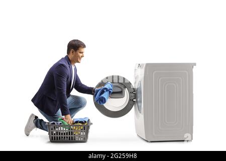 Young man loading a washing machine isolated on white background Stock Photo
