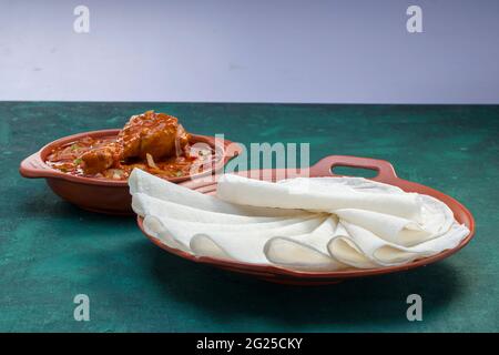 Nice Pathiri with chicken curry ,south indian malabar special food made using rice flour which is white round thin baked food arranged in a terracotta Stock Photo