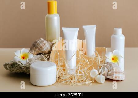 Beauty cosmetic product composition for skincare with sea shell on stone pedestal beige background. Natural cream cosmetic bottle tube mockup with Stock Photo