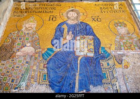 The Empress Zoe mosaic, Hagia Sophia (Turkish: Ayasofya), Istanbul, Turkey. Christ Pantocrator in the middle giving his blessing with the right hand and holding the Bible in his left hand. On either side he is flanked by Constantine IX Monomachus and Empress Zoe in ceremonial costumes. Byzantine art. Stock Photo