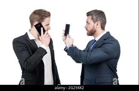 negotiation disagreement of talking man on smartphone and businessman showing phone, argue. Stock Photo