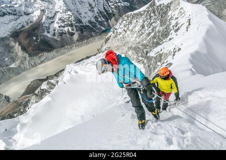 Two climbers contemplate steep drop on Island Peak's headwall Stock Photo