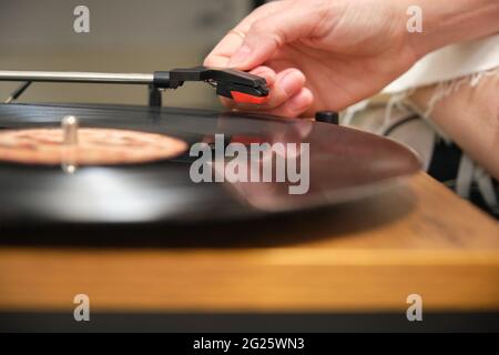 Close up of a hand playing a vinyl record on a turntable Stock Photo
