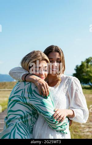 Smiling female best friends hugging each other Stock Photo