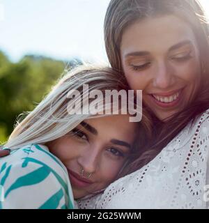 Two girls hugging each other and smiling Stock Photo - Alamy